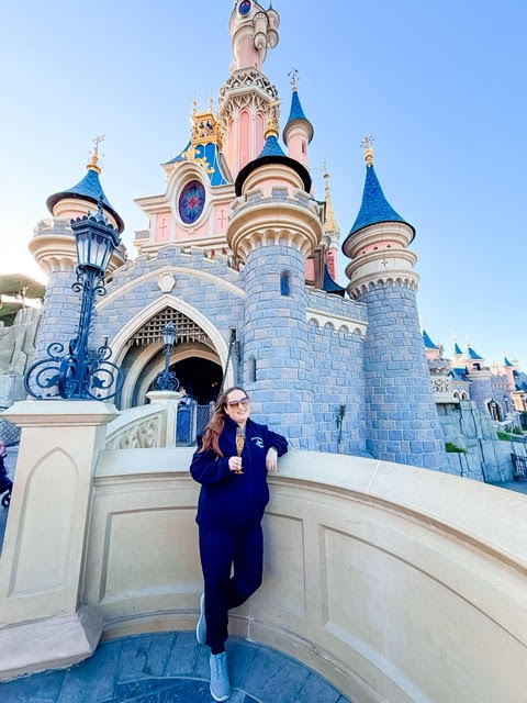 Laura enjoying champagne in front of Sleeping Beauty Castle at Disneyland Paris
