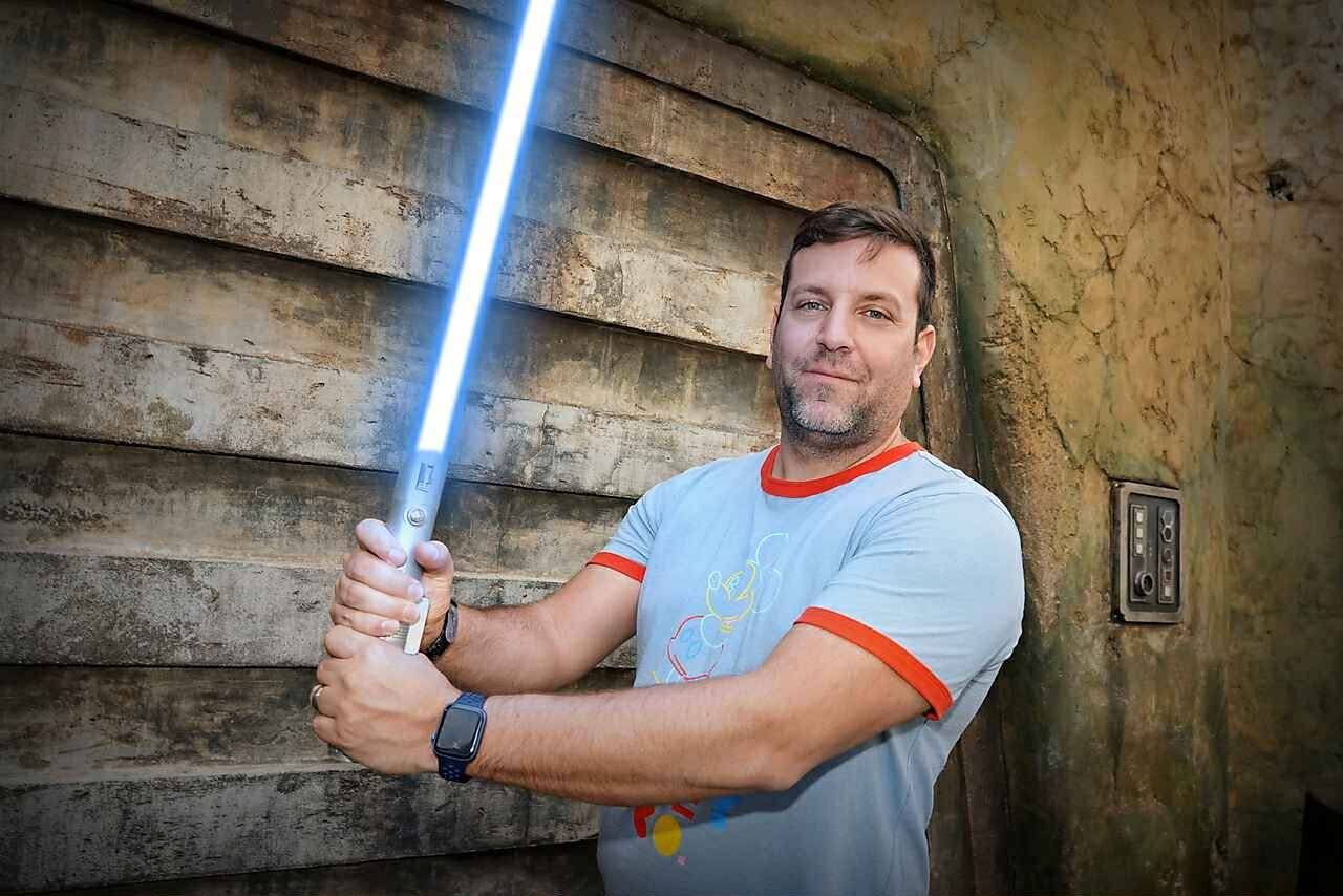 Sean Beauparlant holding a lightsaber at Star Wars Galaxy's Edge