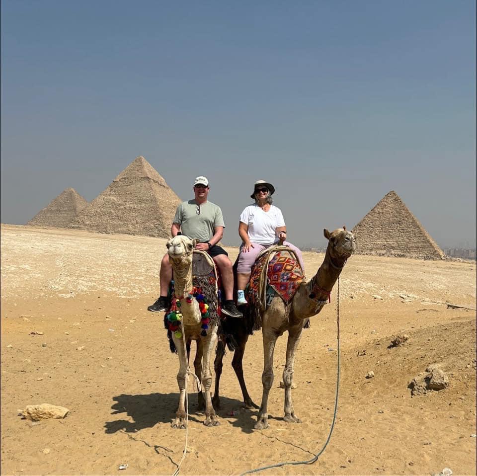 Jen & Steve Maude riding camels in front of the Pyramids of Giza, Egypt