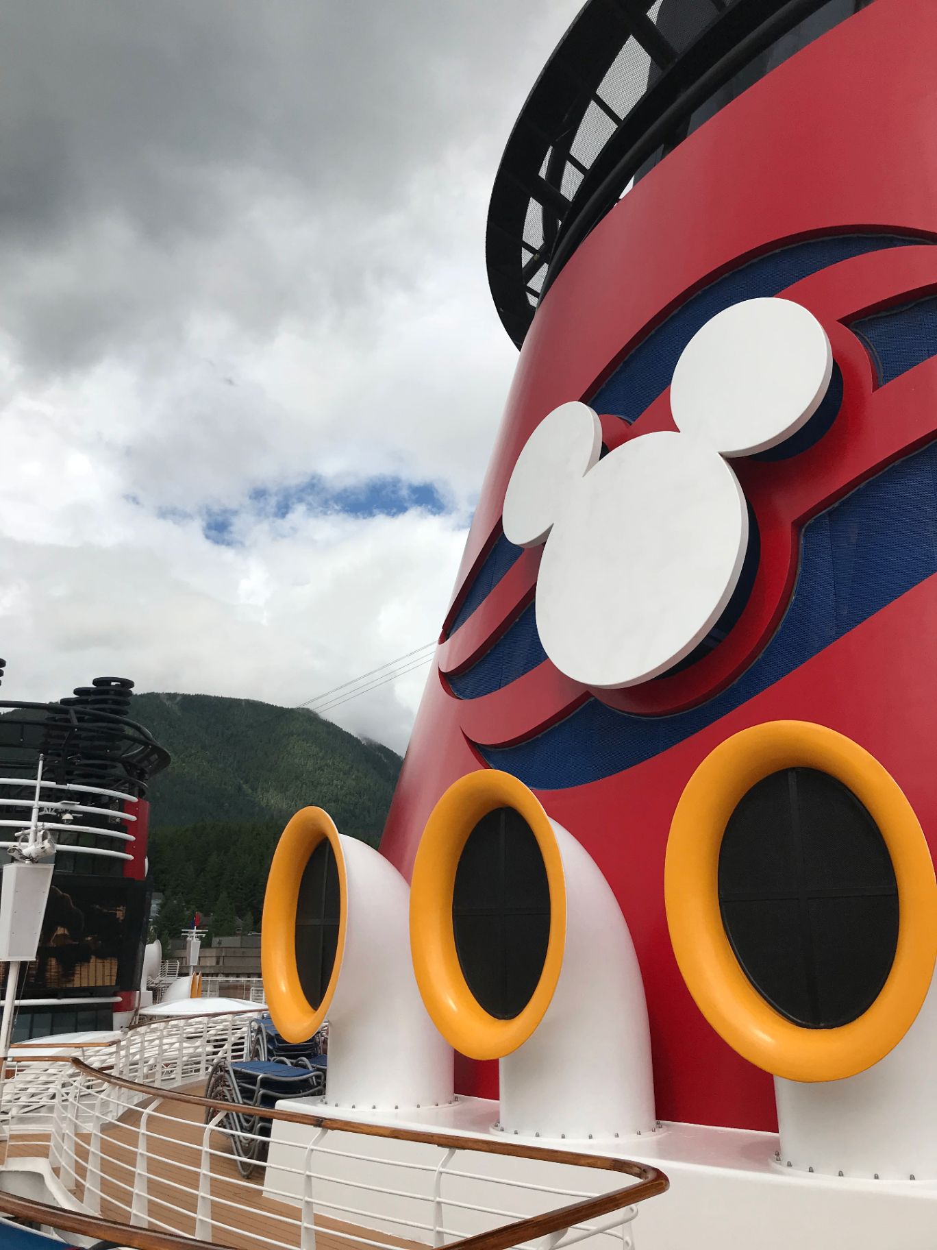 Close-up of a Disney Cruise ship funnel with mountains near Vancouver