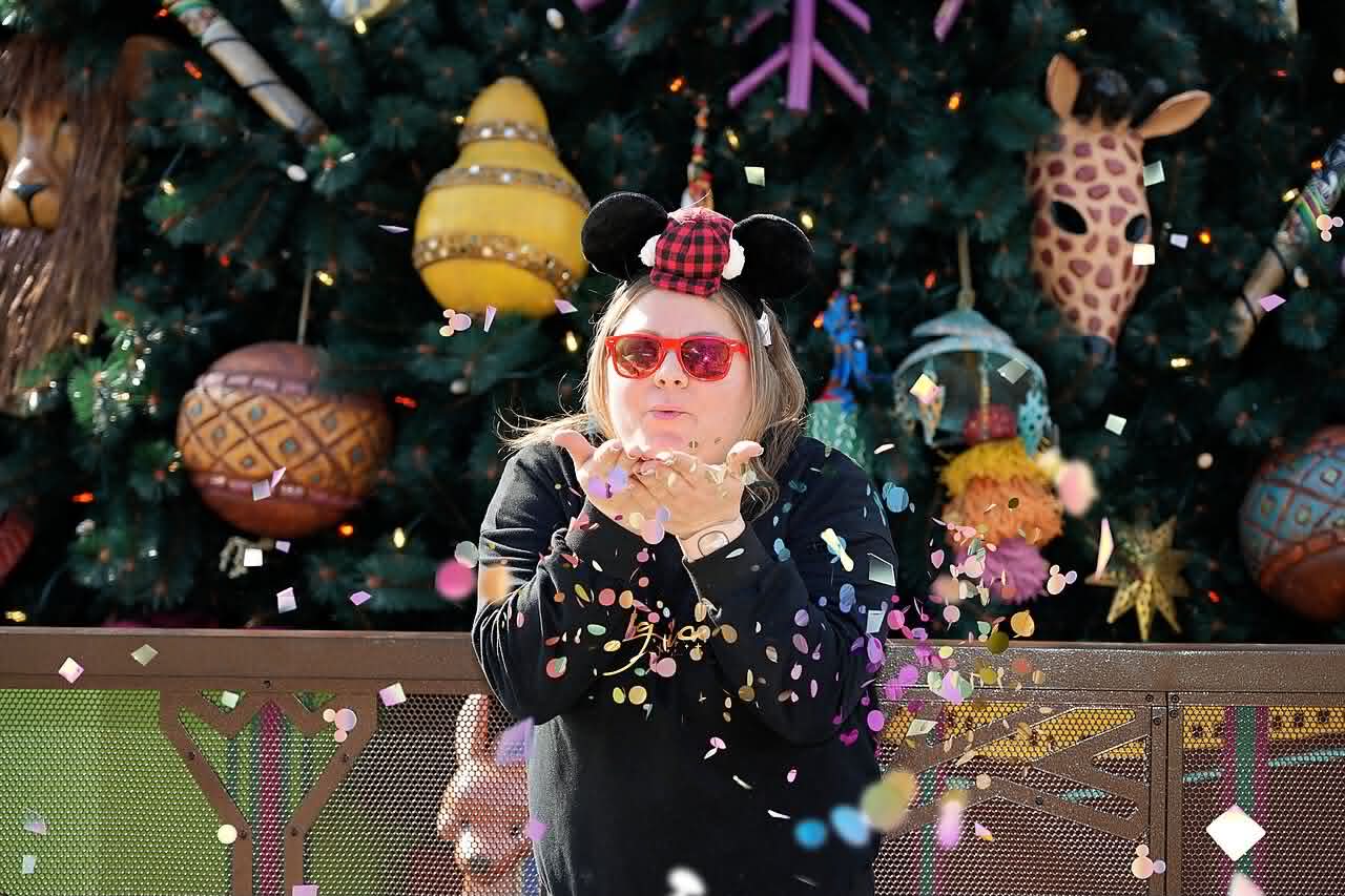 Diana blowing confetti at Disney's Animal Kingdom during the holidays