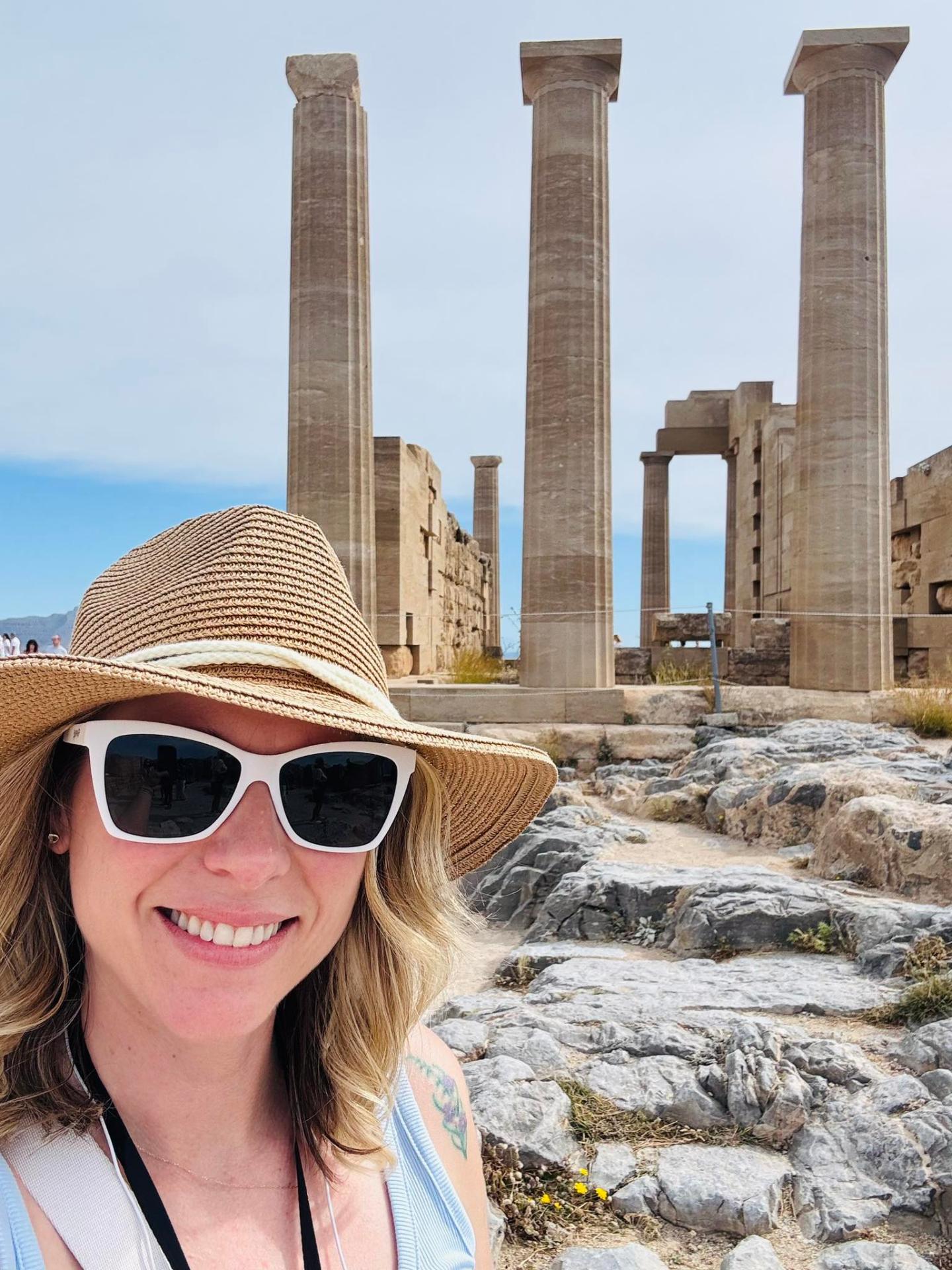 Michelle at the ancient Doric columns of the Acropolis of Lindos in Greece
