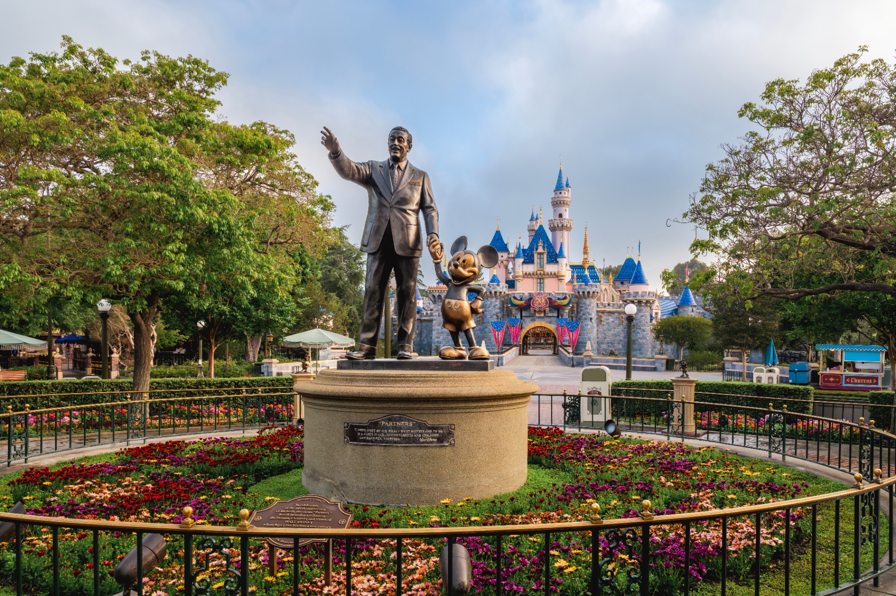 Walt Disney and Mickey Mouse Partners statue in front of Sleeping Beauty Castle at Disneyland Resort in California