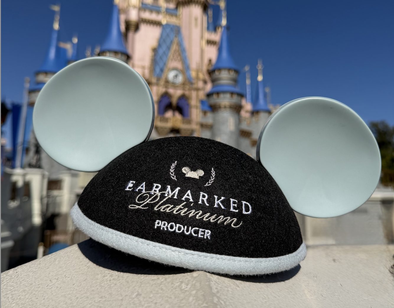 Earmarked Platinum Producer Mickey ear hat in front of Cinderella Castle at Walt Disney World